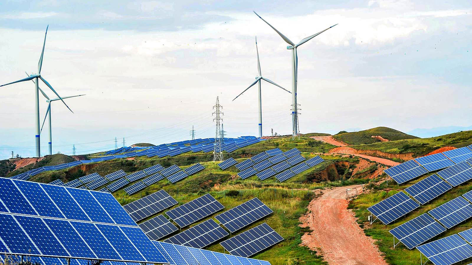 ZHANGJIAKOU, CHINA - JULY 02: Solar panels and wind turbines are pictured on a barren mountain at Shenjing Village on July 2, 2018 in Zhangjiakou, Hebei Province of China. The installed capacity of renewable energy electricity generation in Zhangjiakou has reached 12.03 million kilowatts. (Photo by VCG)